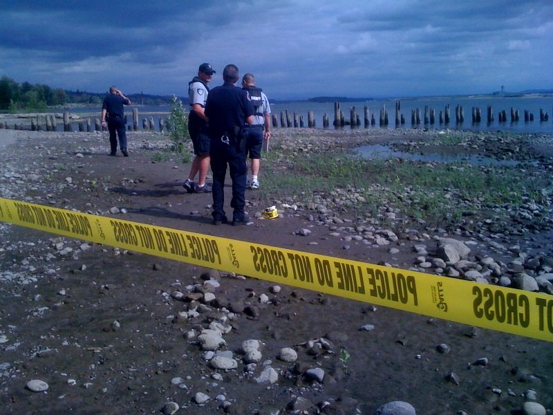 Investigators respond to a report of a body found in the Columbia River near Marine Park in Vancouver on Wednesday.