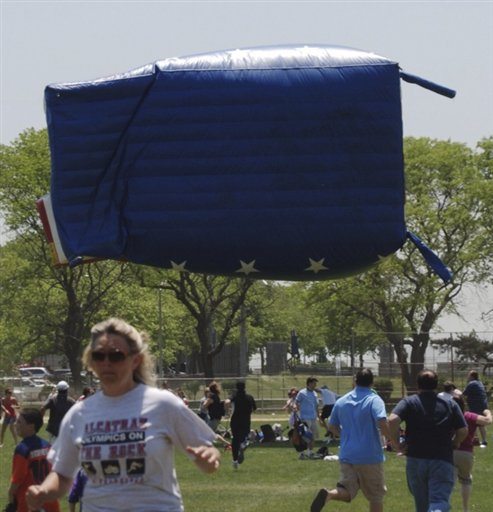 In this June 4, 2011, photograph, participants in an Oceanside, N.Y. soccer tournament run from an airborne inflatable &quot;bounce house&quot; after high winds sent it flying, scattering spectators and injuring 13 people, one critically. Saturday's inflatable mishap is the latest in a growing series of similar accidents, experts say.