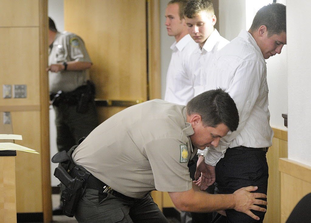 Mitchell Kangas, right, is hand cuffed and patted down by a Clark County custody officer as Jaren Koistinen, center, and Riley Munger, far left, wait to go to jail after being sentenced Tuesday.