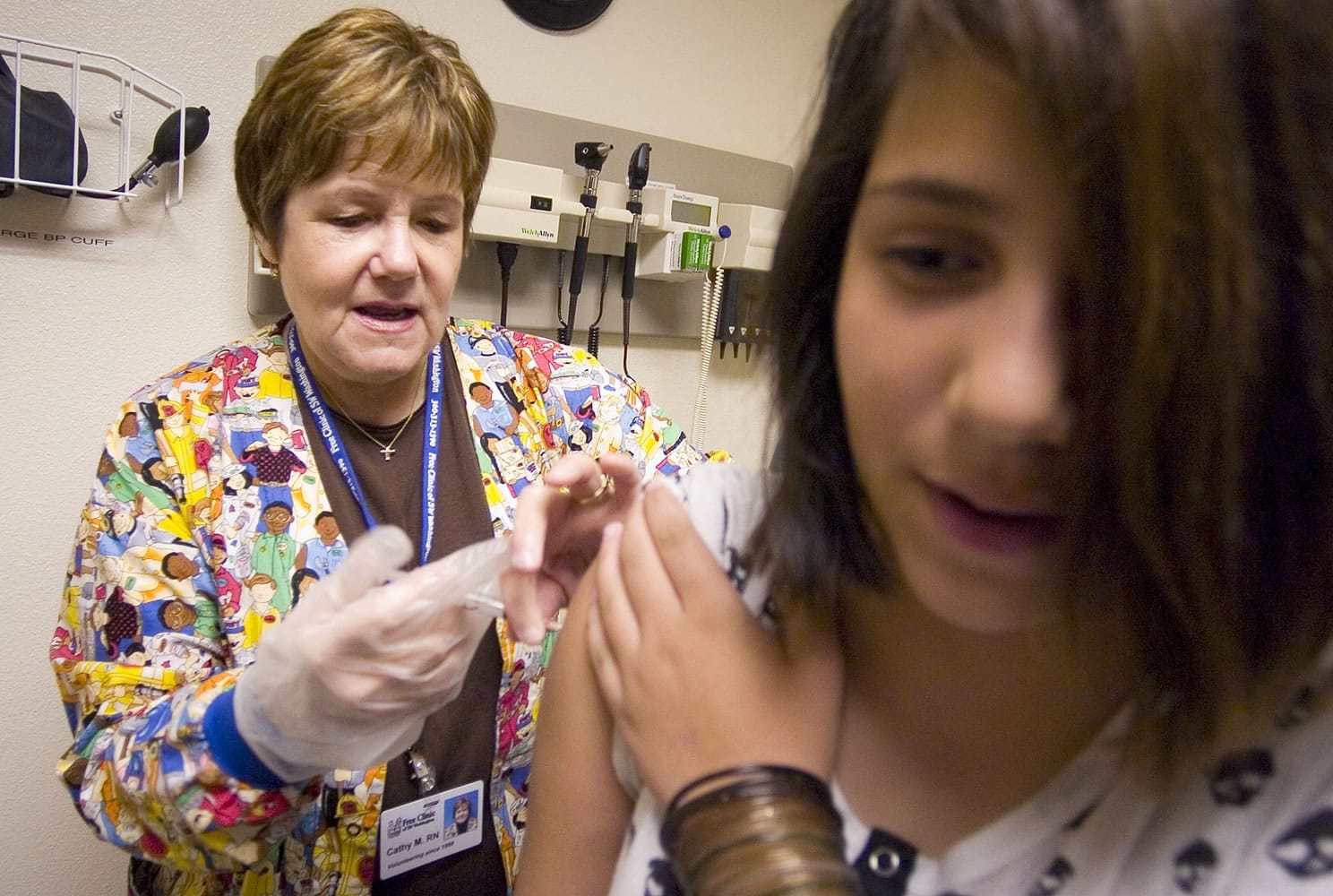 Cathy McCann, left, gives Katelyn Smith, then 11, from Vancouver, a back to school immunization shot in 2007 at the Vancouver Free Clinic.