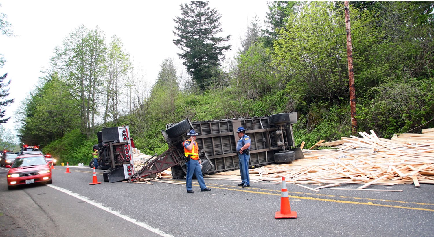 A semi with double flatbed trailers went on its side and dumped a load of lumber on state Highway 14 in Skamania County on Sunday night.