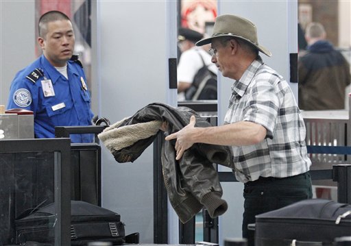 This April 30, 2012, photo shows a traveler passing through a security check point at Portland International Airport, in Portland, Ore.