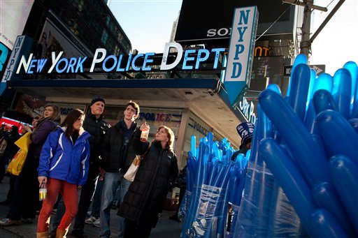 Bundles of balloons and curious pedestrians wait at a crosswalk outside the Times Square police station as city police officials begin ramping up security before Saturday's New Years Eve celebrations, Friday, Dec. 30, 2011, in New York. Behind the scenes, the police meticulously map out how to control crowds that can swell to 1 million while also preparing for potential terror threats.