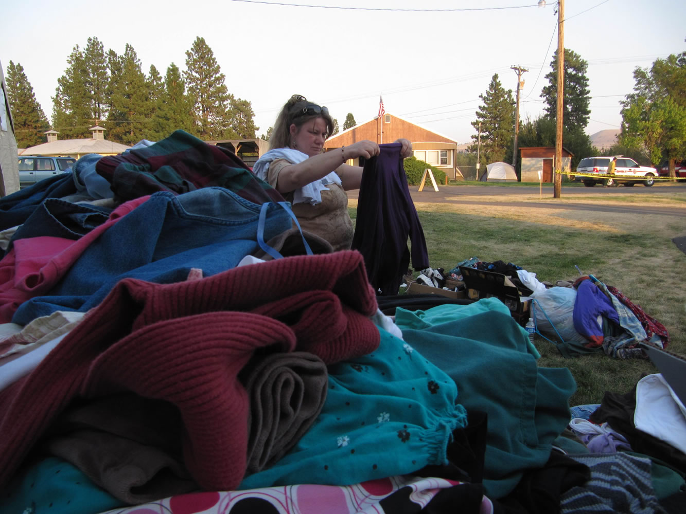 Linda Hodges, who has been evacuated from her home near Goldendale, looks through donated clothing at a Red Cross shelter on Friday. More than 200 residents of tinder-dry forests near Washington state's Satus Pass crowded a high school gymnasium to get an update on a wildfire that has burned 64 buildings on Friday. Hundreds of people in the south-central part of the state have been evacuated.