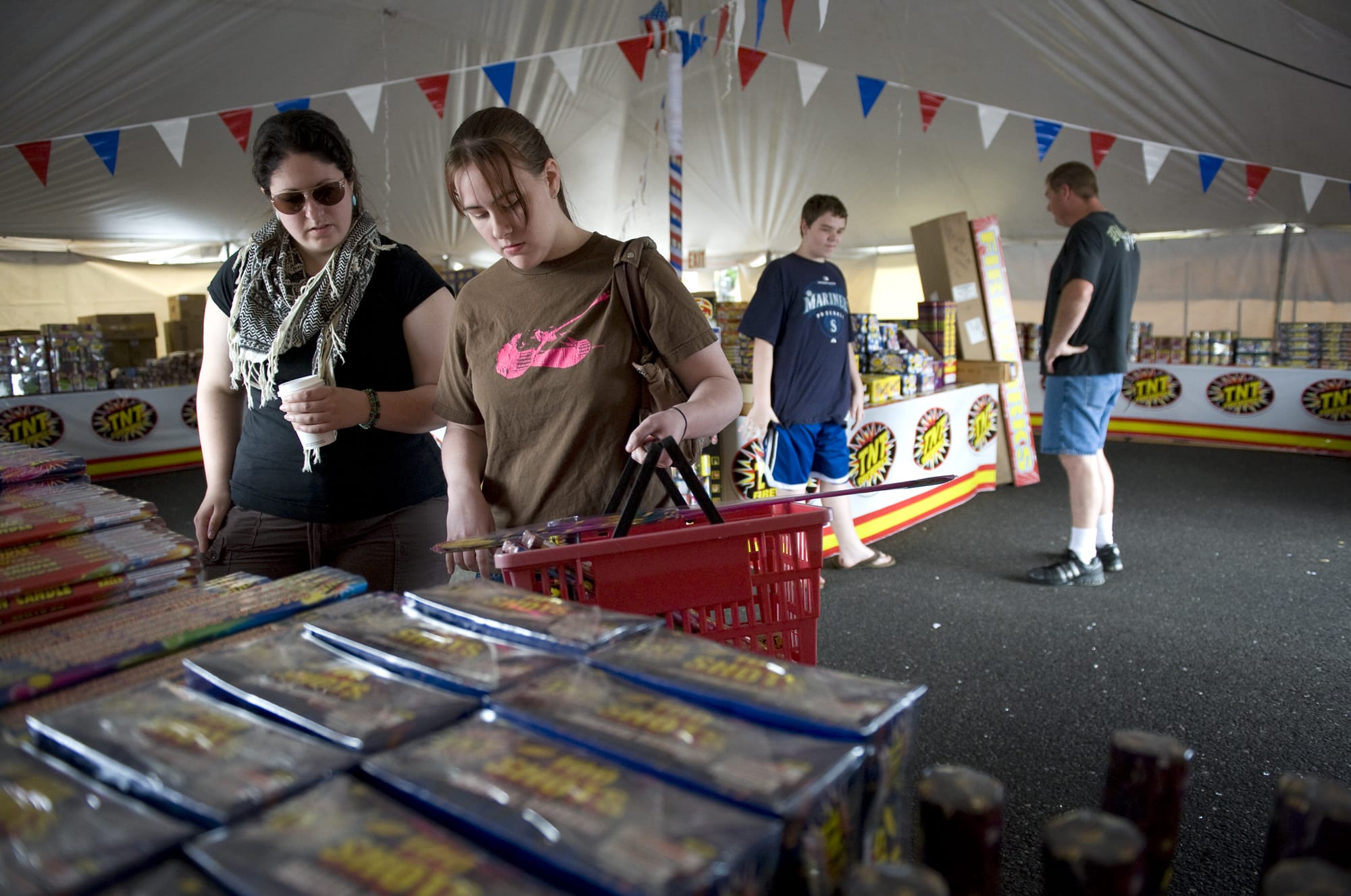 Veteran fireworks buyer Verity Wallis, 26, left, helps her friend Becky Kalhar, 26, purchase fireworks for her first time at the TNT Fireworks stand at SE Mill Plain Boulevard and SE Chkalov Drive on Monday June 28, 2010.