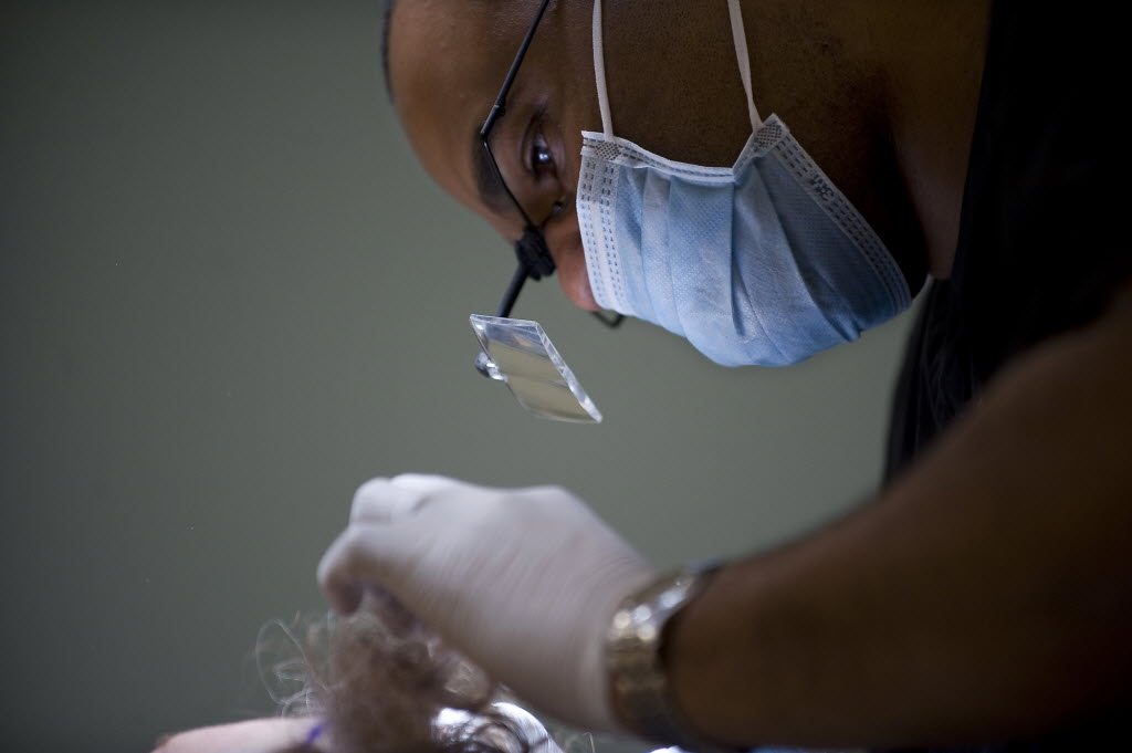 Lead NeoGraft Technician Robert Alvarado makes incisions in a 66-year-old female patientOs scalp where her transplanted hair follicles will be placed, at Salmon Creek Plastic Surgery