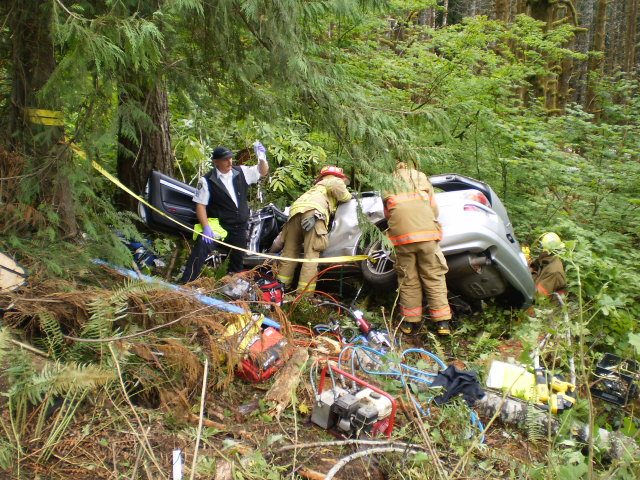 Rescuers work to free a trapped Vancouver teenager from the wreckage of his car near Elsie, Ore.