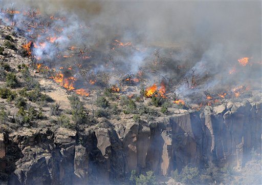 The Las Conchas Fire burns along the top of a mesa, Wednesday, June 29, 2011 in Los Alamos, N,M. The government sent a plane equipped with radiation monitors over the Los Alamos nuclear laboratory Wednesday as a 110-square-mile wildfire burned at its doorstep, putting thousands of scientific experiments on hold for days.