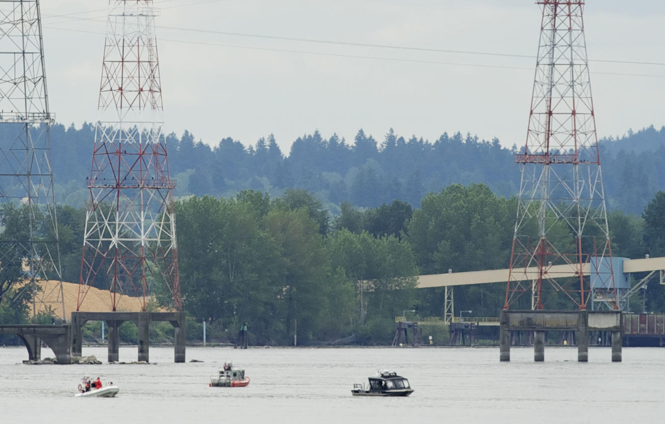 Rescue boats search the area Monday where a fishing boat capsized on the Columbia River near Camas. Three people on the boat went into the water.