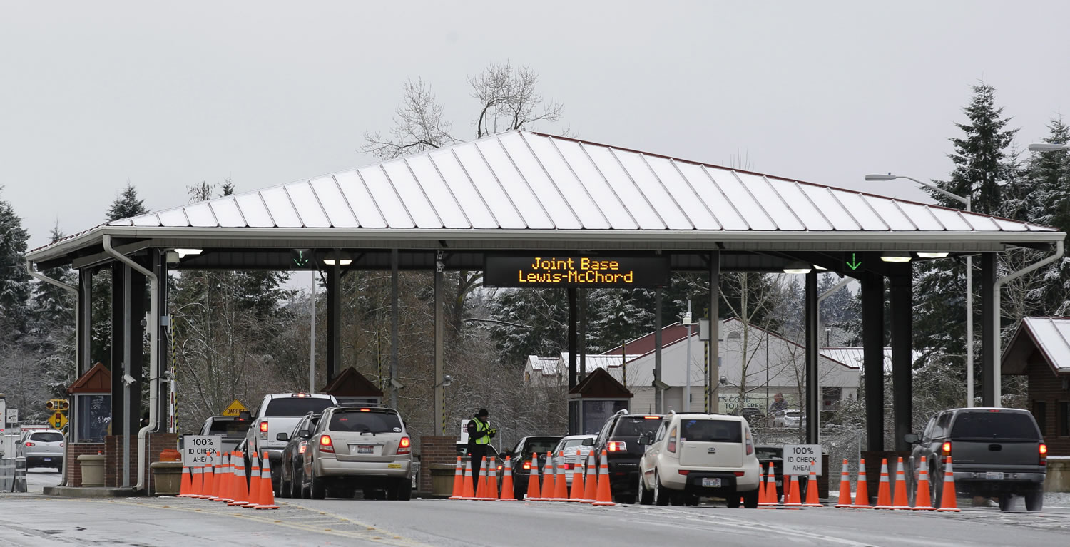 Guards check the identification of drivers passing through a gate at Joint Base Lewis-McChord on Tuesdayin Washington.