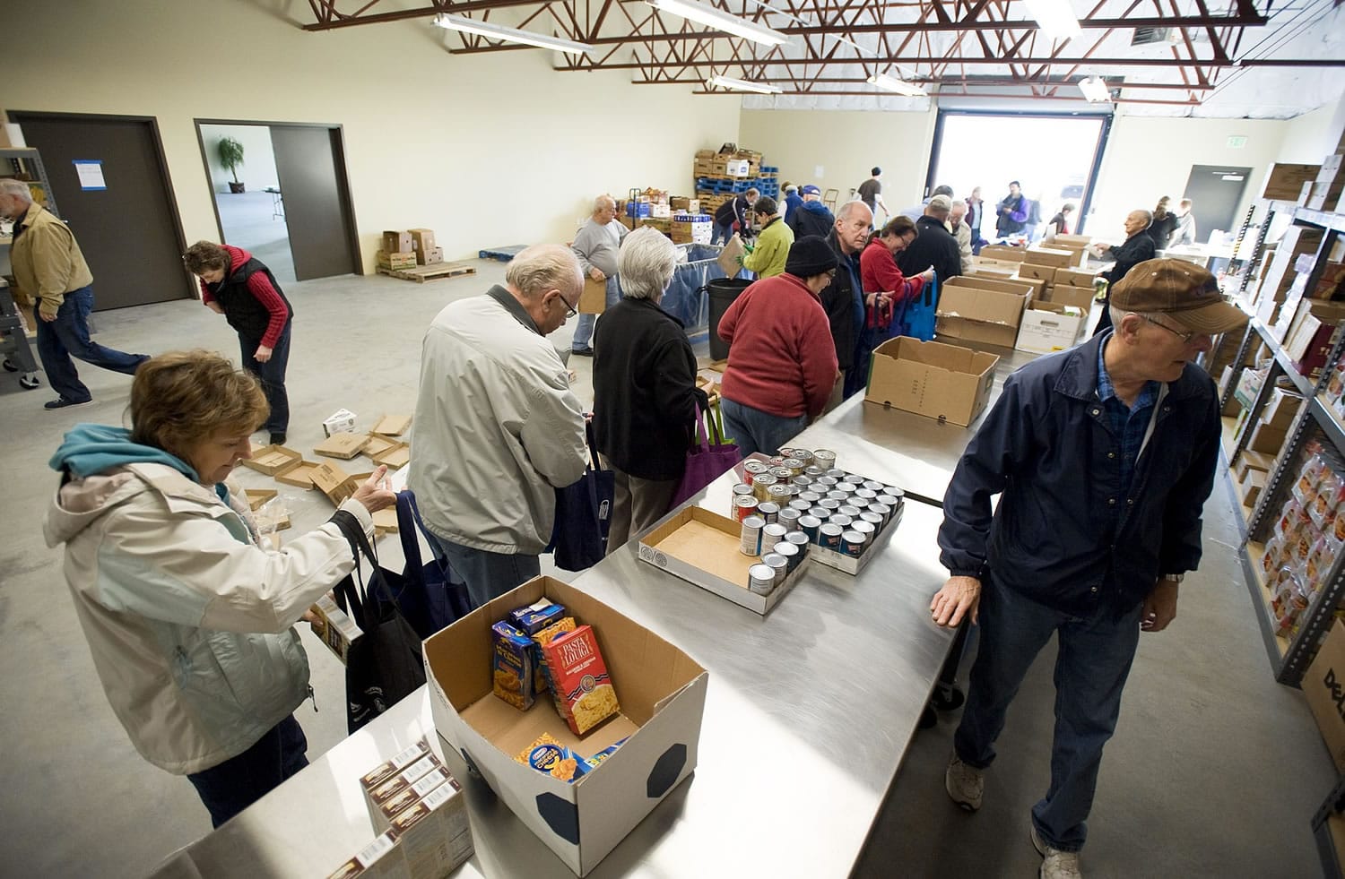Volunteers fill bags with food for the Share Backpack Program to help hungry school-age kids.