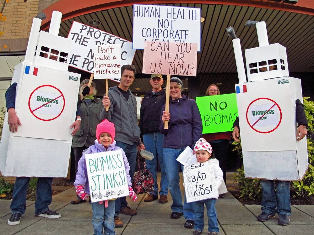 People opposed to a proposed biomass plant in downtown Vancouver protest Tuesday evening outside of Battle Ground City Hall, where county commissioners met for their weekly meeting.