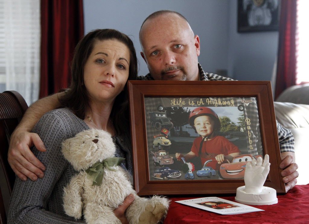 In this Jan. 26 photo, Ed and Kristie Owens hold a photo collage of their deceased son, Eddie Ryan Owens, along with his favorite teddy bear and a plaster hand casting at their home in Battle Ground.