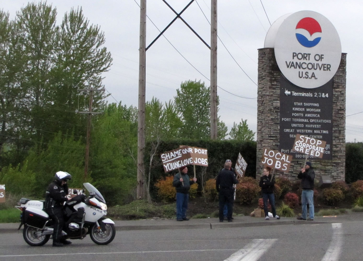 A group of demonstrators held signs outside the main entrance to the Port of Vancouver on Thursday morning.