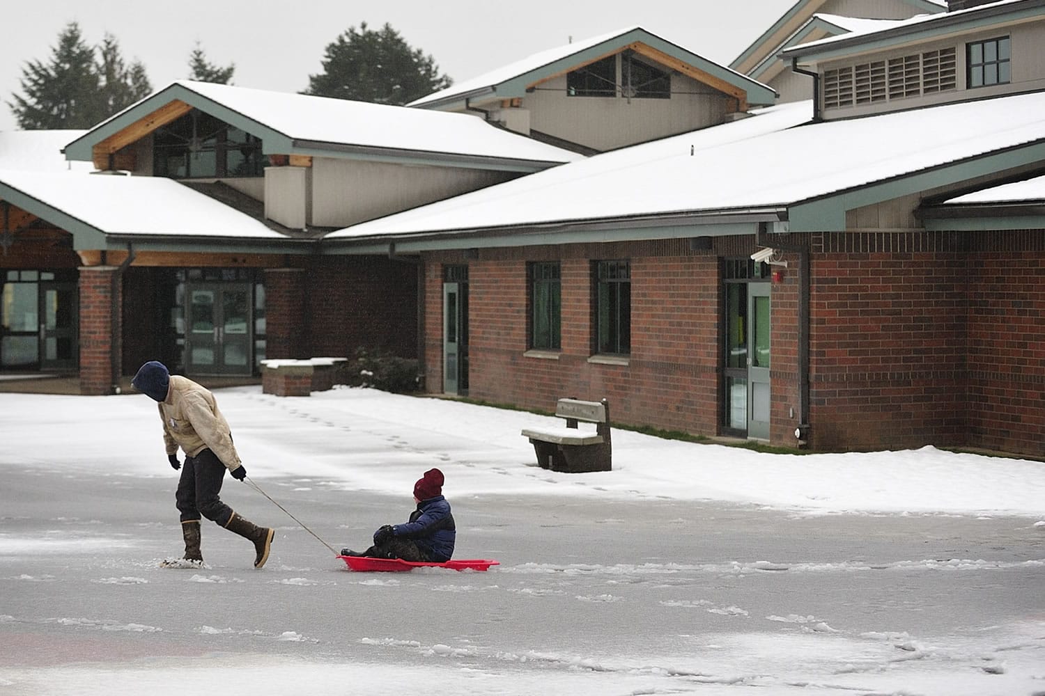Dan Friesz, left, pulls his son, Nathan, 9, in a sled at Franklin Elementary School Wednesday.
