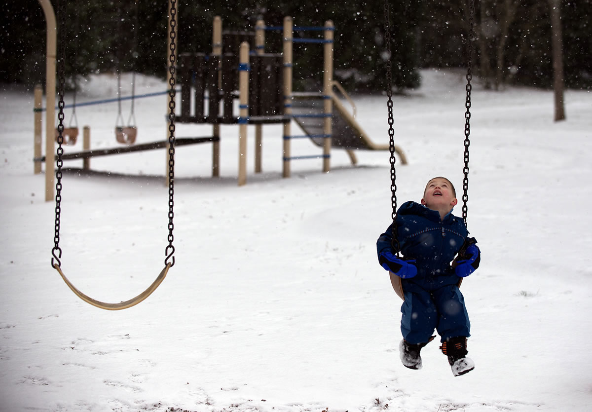 Maximus Cieloha, 4, of Vancouver watches as snowflakes fall from the sky while playing at Wy’East Community Park with his mom, Carissa, not pictured, on Sunday morning, January 3, 2016.