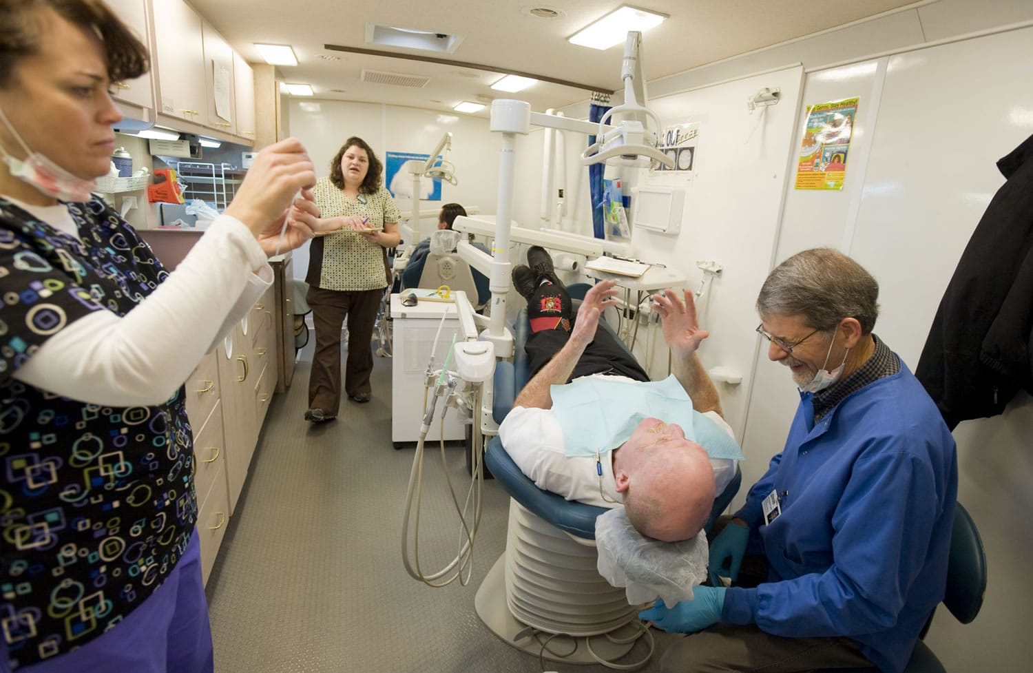 John Burkhart, DMD, right, prepares to extract a tooth from Marine veteran Benjamin Ross at the Free Clinic of Southwest Washington's dental van, Monday, January 31, 2011.