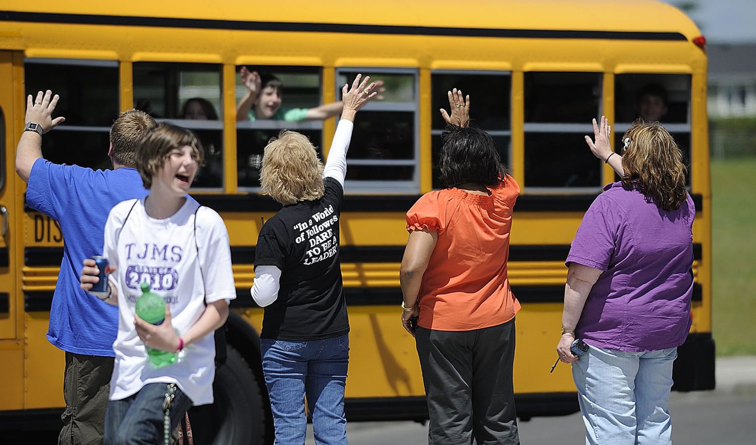 Staff and faculty at Thomas Jefferson Middle School wave goodbye to buses filled with students as they head home for summer break June 22, 2010 in Vancouver, Washington.
