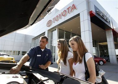 Billy Garlin, left, a sales and leasing consultant at the Big Two Toyota Scion of Chandler (Ariz.) car dealership, shows Lacey Rivera, middle, and her sister Shelbey Kearns a new car Rivera had just purchased last week.