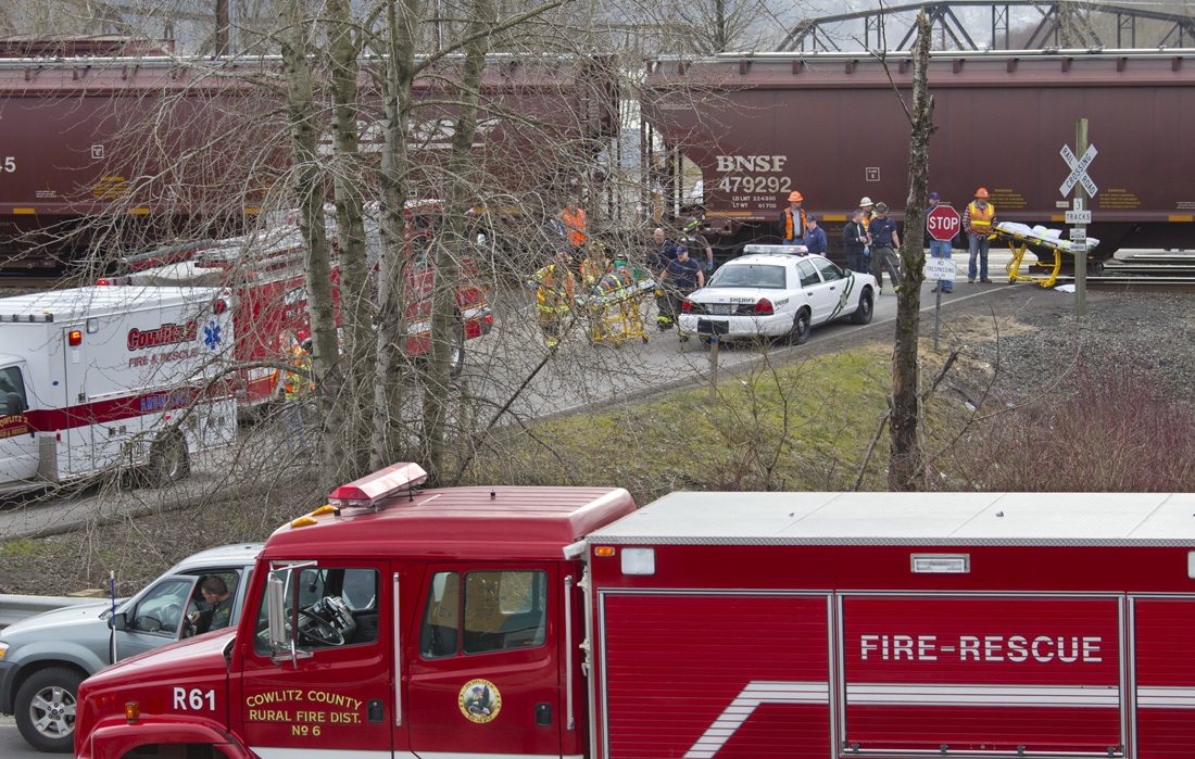 Emergency personnel transport an injured passenger to an ambulance from the shuttle vehicle which was hit by a northbound train at a private crossing at the Longview Junction near the Harry Morgan Bridge in Kelso in March, 2011.