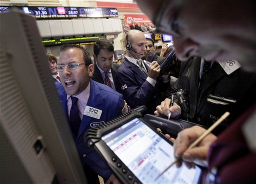 Specialist Michael Pistillo, left, calls out prices as he works at his post on the floor of the New York Stock Exchange Wednesday, July 27, 2011.
