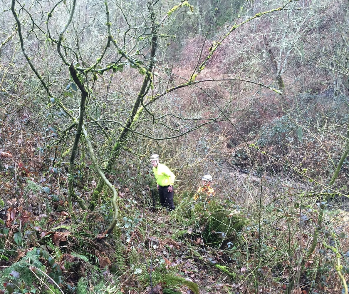 Search and rescue personnel pick through a woody ravine Thursday northeast of Columbia River High School to find a metal implement one student used to club another at the school that day.