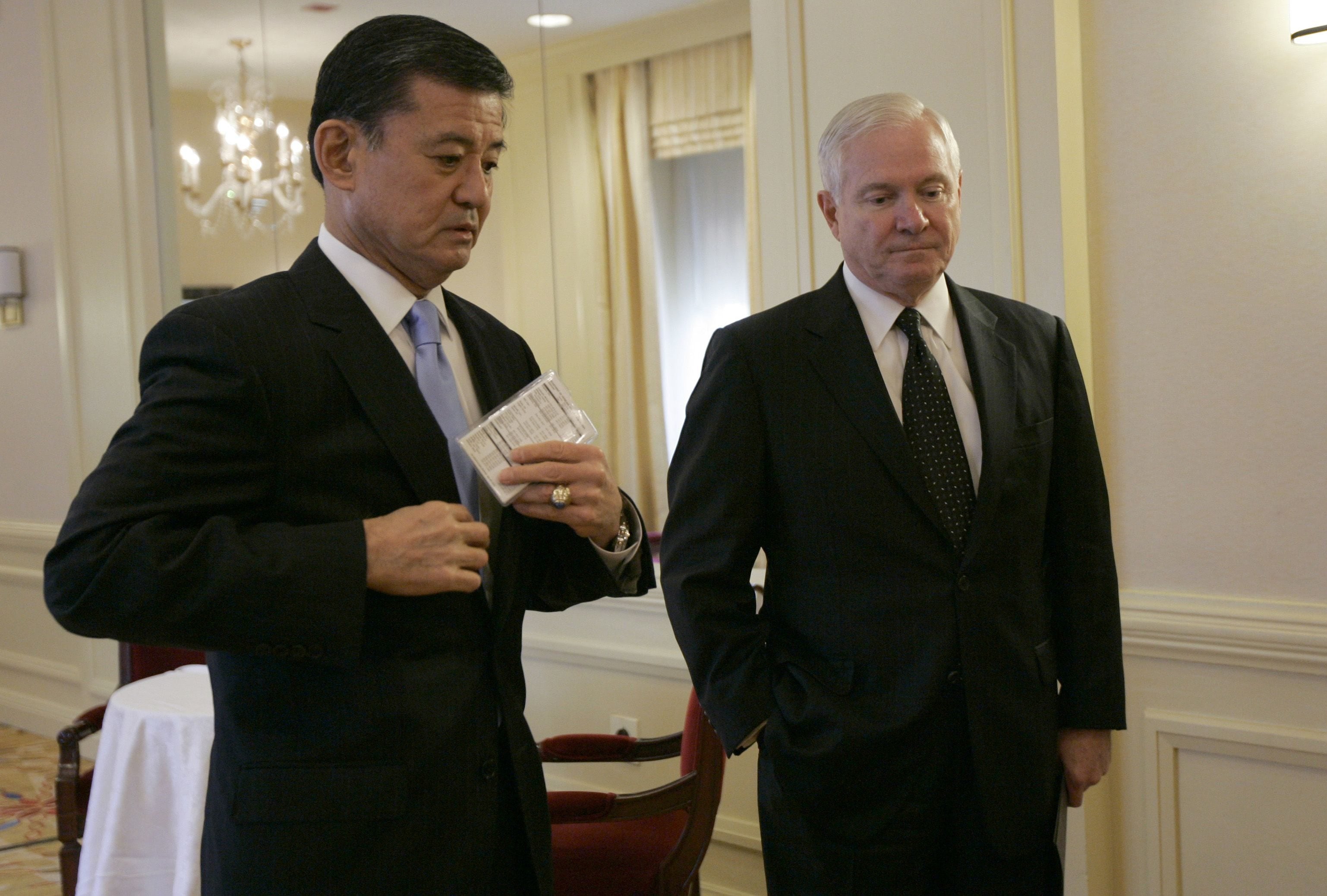 Defense Secretary Robert Gates, right, and Veterans Affairs Secretary Eric Shinseki wait to speak in 2009 at a Mental Health Summit to discuss a public health model for enhanced health care for returning service members in Washington.