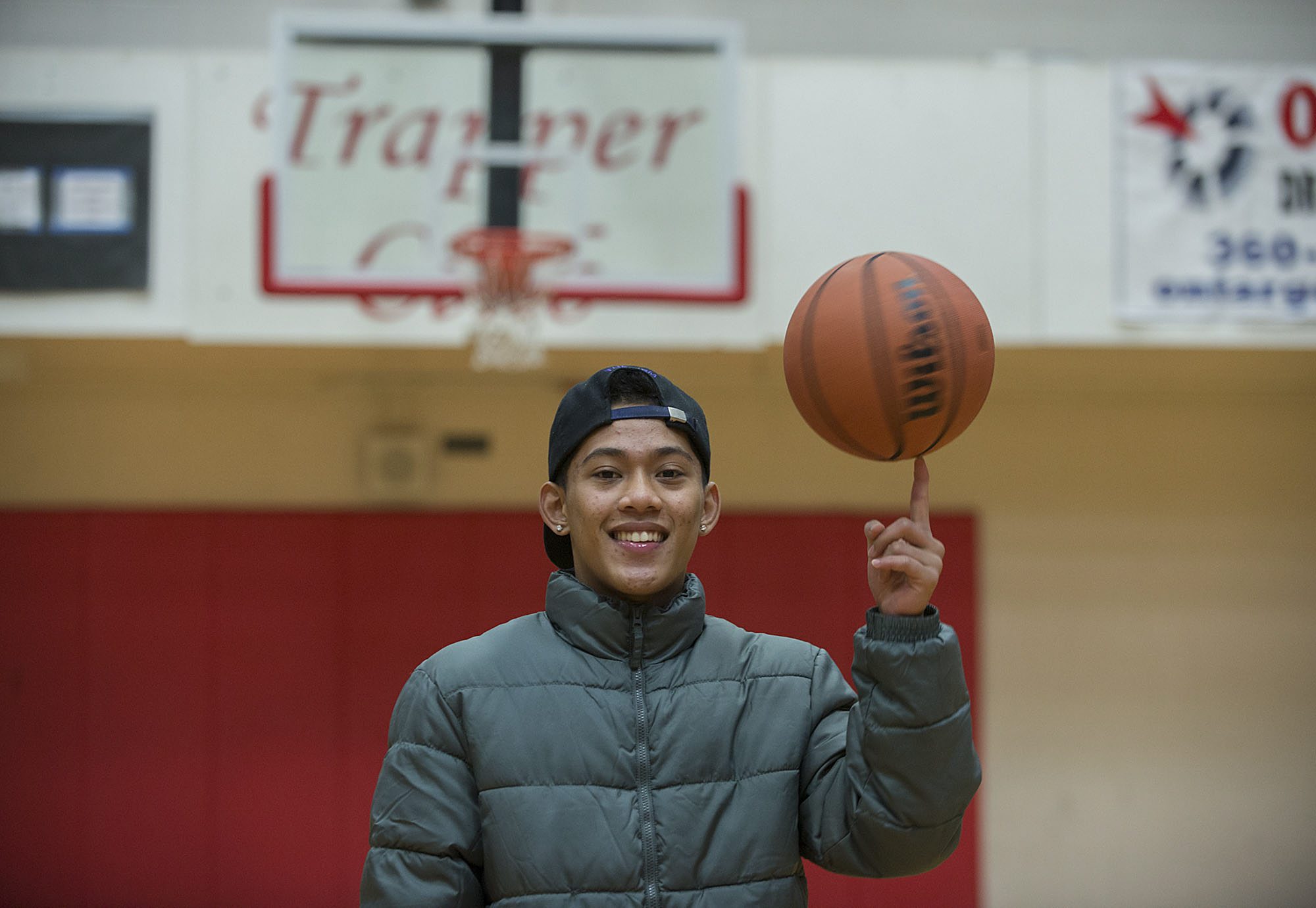 A.J. Yosuo, 17, spins a basketball on his index finger Dec. 17 at Fort Vancouver High School.  A.J. plays varsity basketball for the Trappers. Last year, his family was homeless.