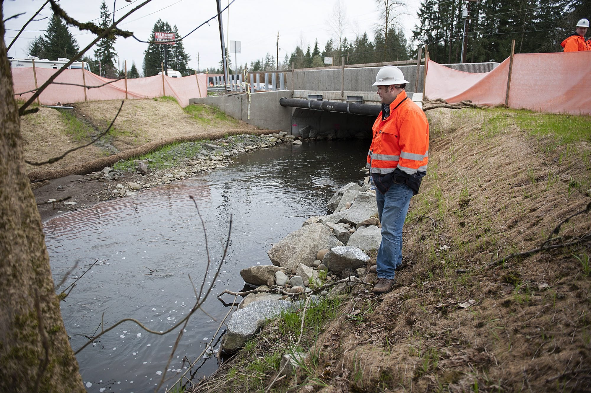 Kevin Workman of the Washington State Department of Transportation looks over a recently constructed culvert at Mill Creek along state Highway 502 near Battle Ground on Monday. Modern culverts are designed and installed to mesh with all life phases of migratory fish.
