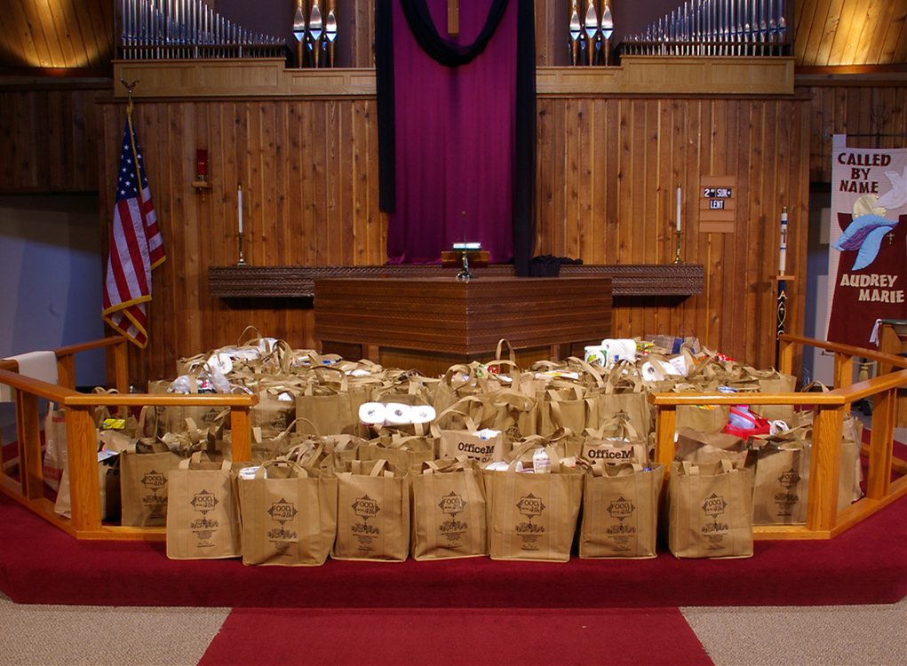 Food collection for the fourth Sunday is placed around the altar as a visible offering.