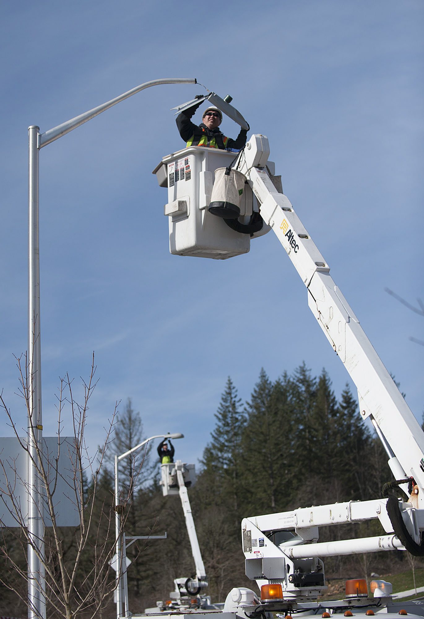 Vlad Romanov of Lumenal Lighting, foreground, joins colleague Jerry Plunkett as they install LED bulbs in streetlights along Northeast Tanoak Drive in Camas as part of the city&#039;s $3 million project to replace all streetlights with LEDs.