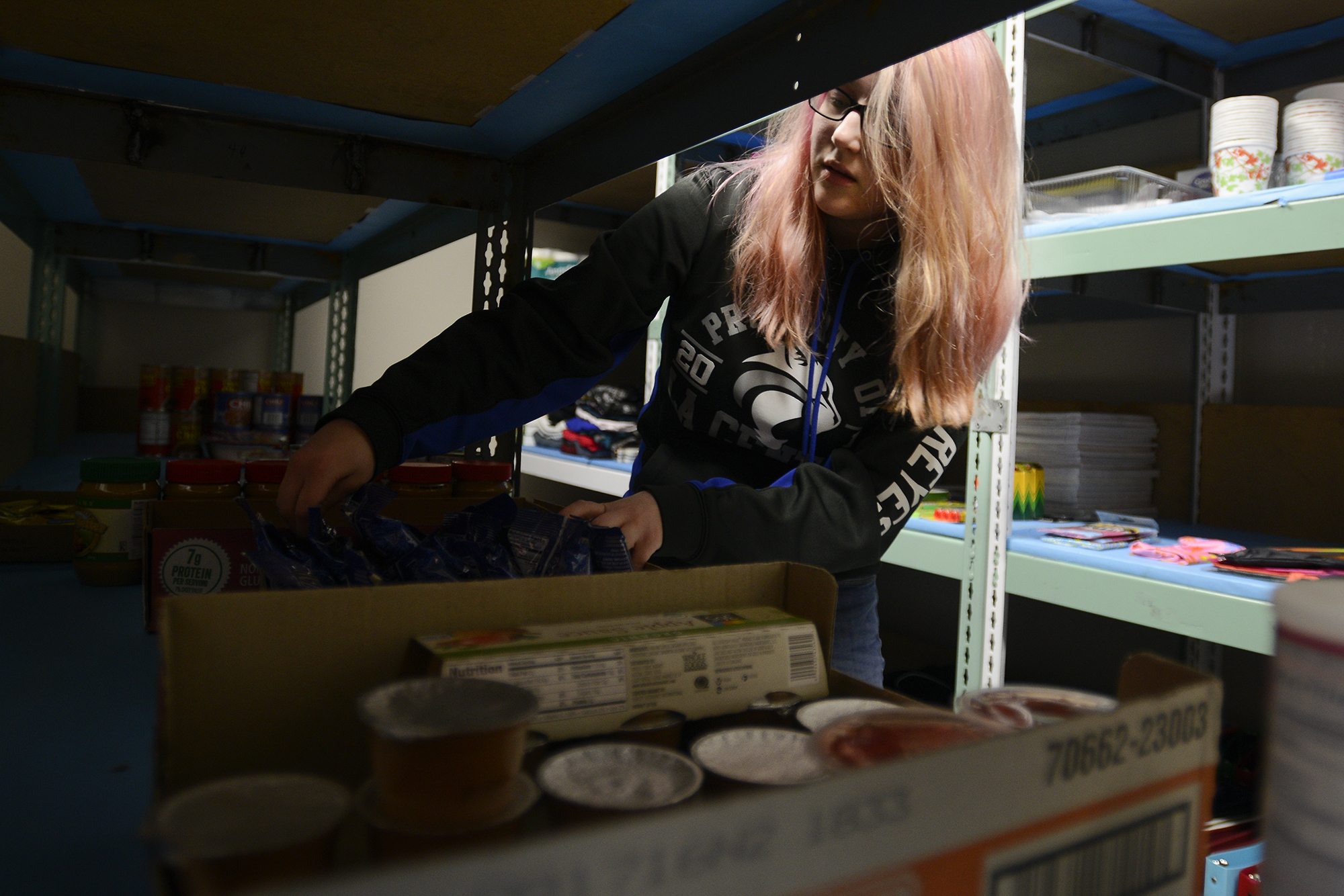 Sophia Reyes, a senior at La Center High School, organizes food in the school&#039;s food pantry on Feb. 16. With a growing population of students who are going hungry, the local nonprofit, Lewis River Mobile Food Bank, worked with the school to start the food pantry.