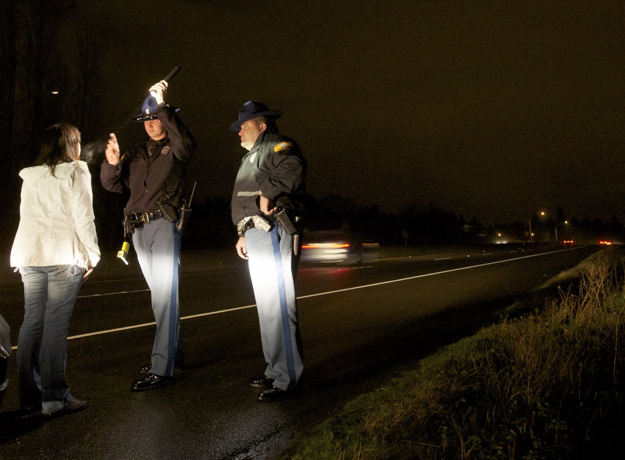 A Washington State Patrol cadet , center, administers a field sobriety test on a suspected DUI stop under the supervision of Trooper Bennie Taylor on Highway 14 in Vancouver in 2012.
