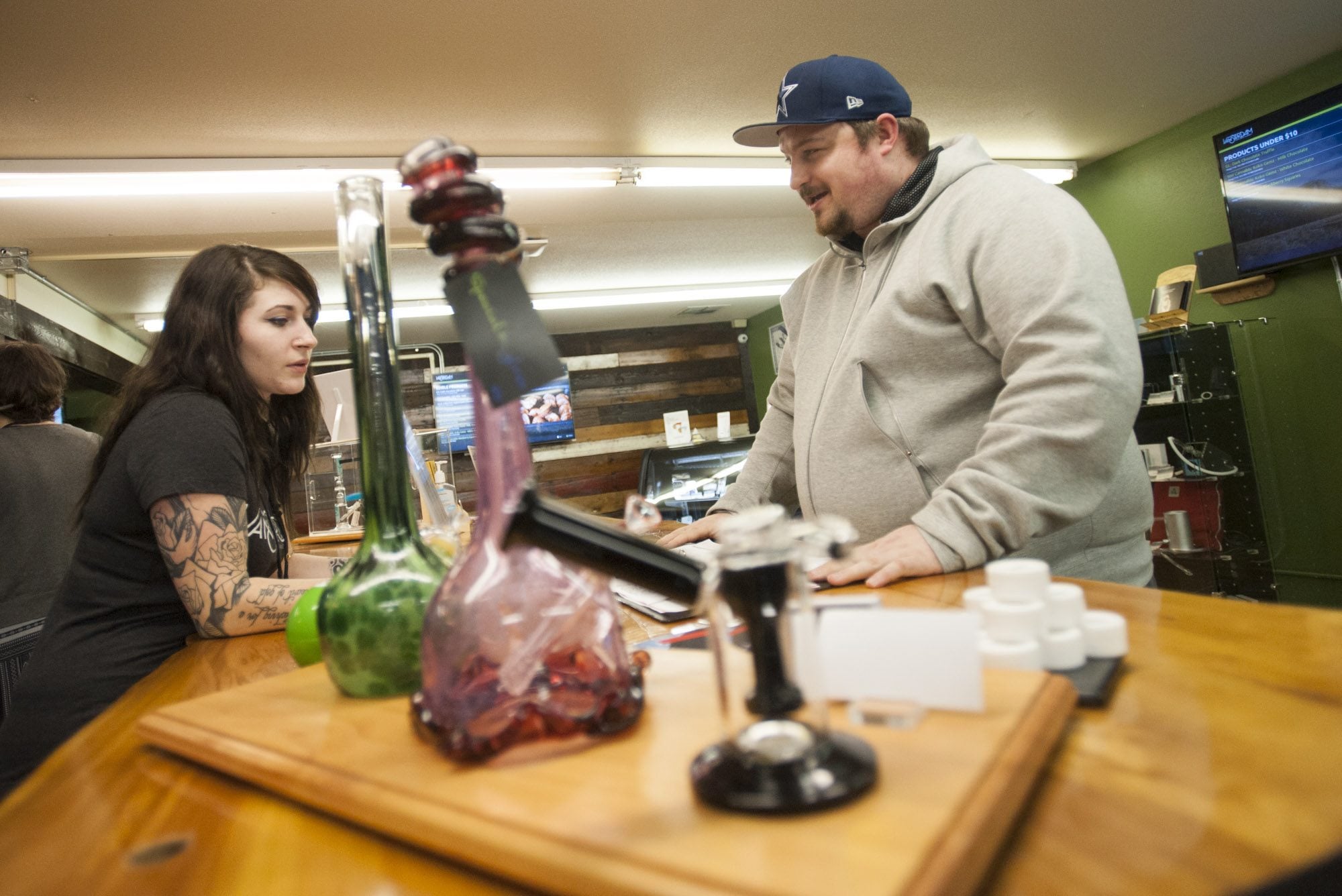 New Vansterdam retail marijuana shop assistant Jacy Reichlin helps customer Matt Ellis on Monday in Vancouver. The Vancouver City Council on Monday voted to increase the number of retail pot shops in the city from six to nine.