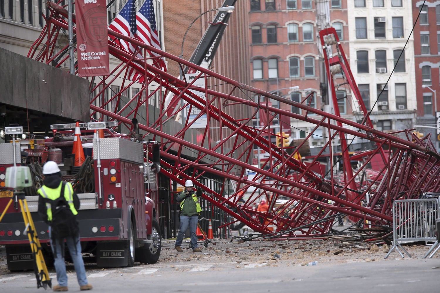 Firefighters and construction crews work Saturday on clearing the wreckage of a 565-foot crane that collapsed Friday morning in New York.