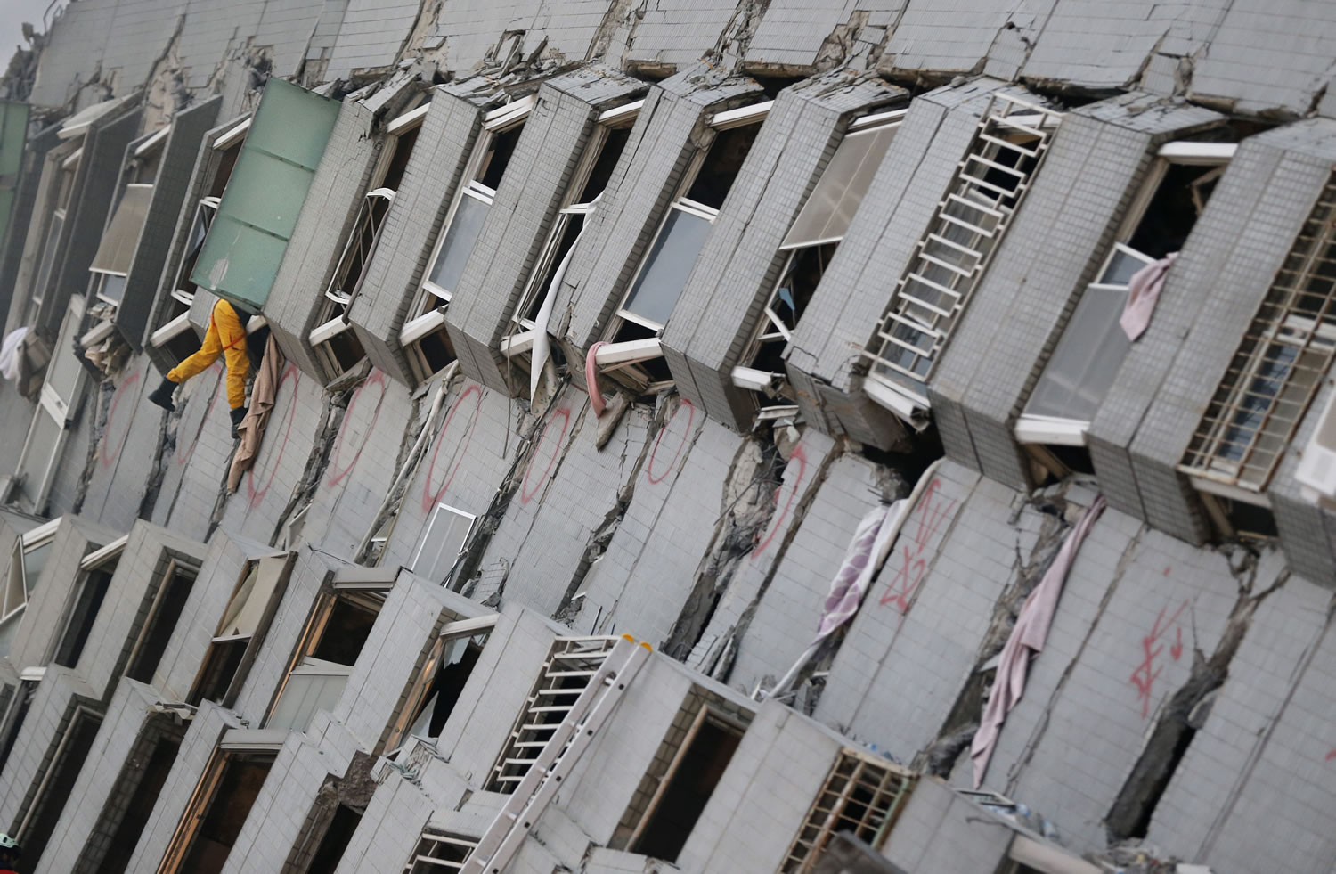 A rescue team member searches for missing people in a collapsed building, after an early morning earthquake in Tainan, Taiwan, Saturday, Feb. 6, 2016. A 6.4-magnitude earthquake struck southern Taiwan early Saturday, toppling at least one high-rise residential building and trapping people inside.