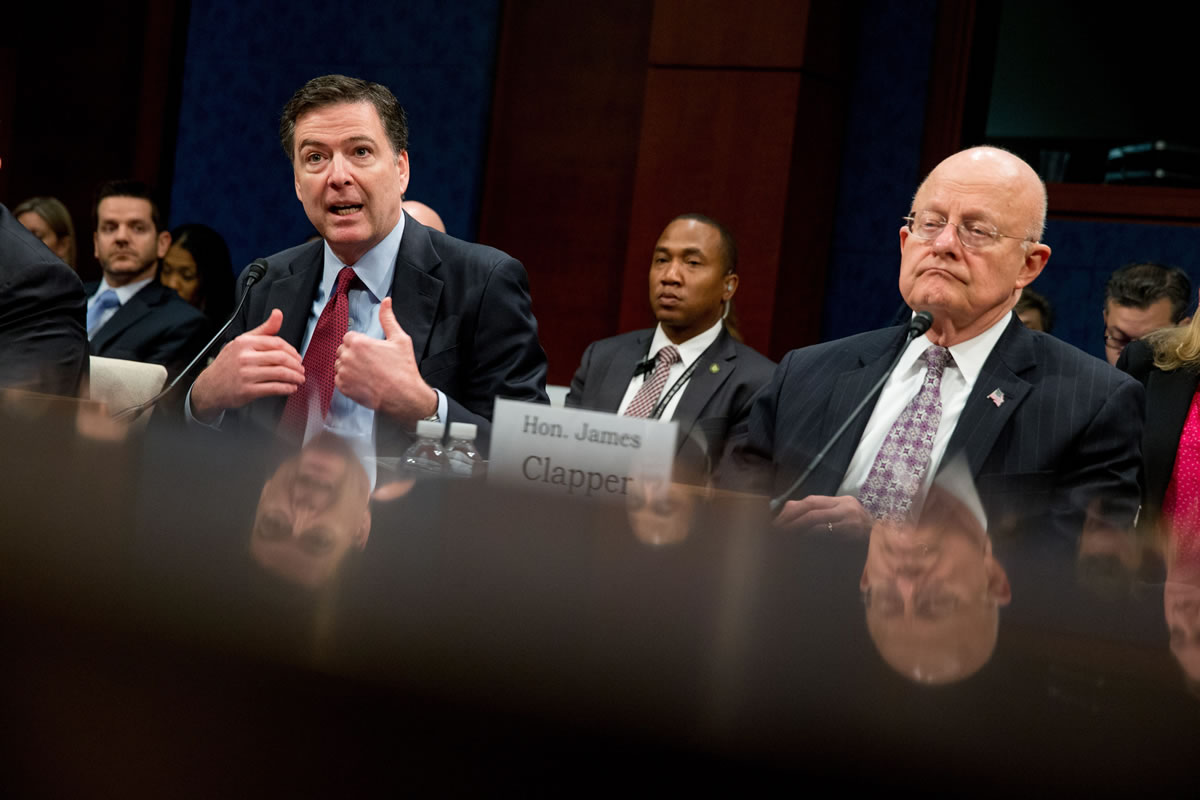 FBI Director James Comey, left, accompanied by Director of National Intelligence James Clapper, right, speaks at a House Intelligence Committee hearing in Washington.