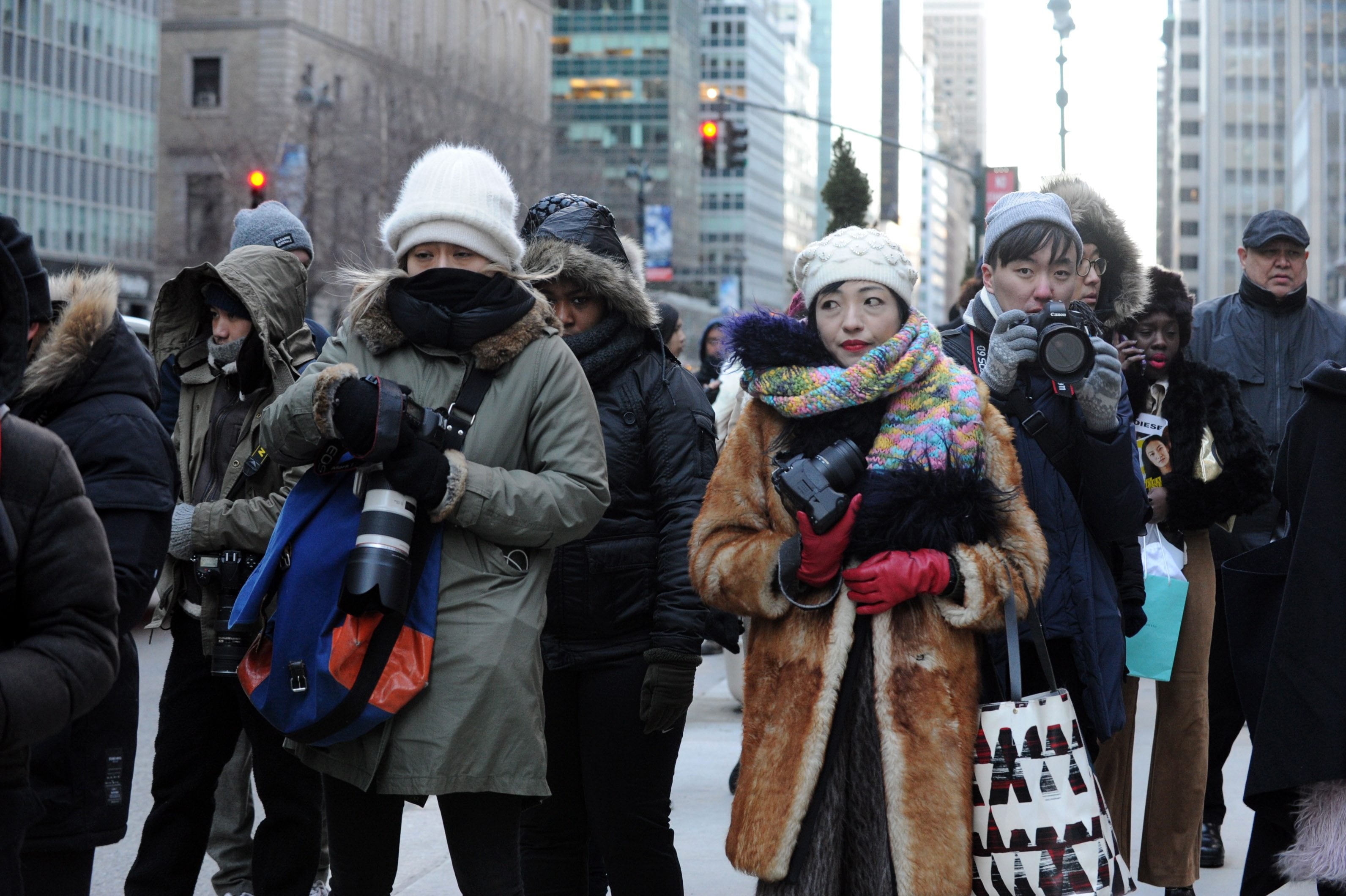 Street photographers brave the cold to photograph guests arriving to the Alexander Wang Fall 2016 show during Fashion Week, Saturday, Feb. 13, 2016, in New York. With temperatures continuing to drop throughout the day Saturday, Mayor Bill de Blasio urged New Yorkers to stay safe and warm by limiting time outdoors, reporting heat and hot water conditions to 311, and checking in on vulnerable friends, relatives and neighbors.