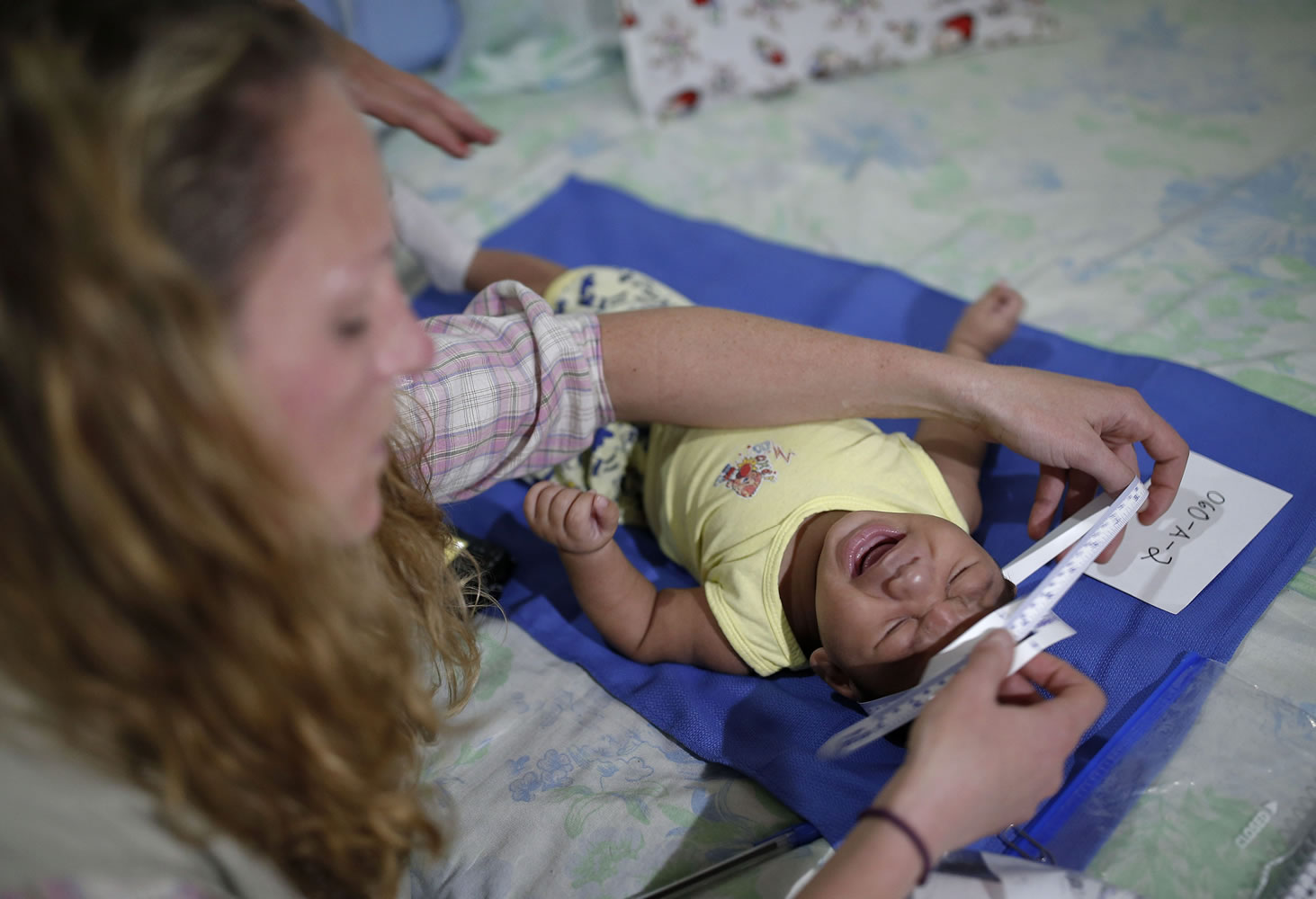 Pediatrician Alexia Harrist from the U.S. Centers for Disease Control and Prevention examines 3-month-old Shayde Henrique, who was born with microcephaly, Tuesday in Joao Pessoa, Brazil.