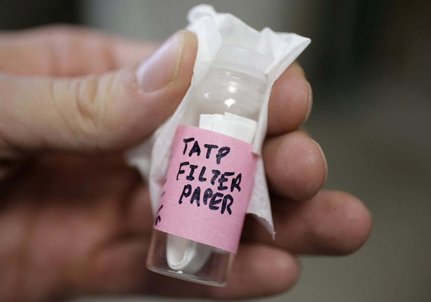 Zachary Caron, of Hope, R.I., a chemical engineering graduate student at the University of Rhode Island, displays a vial containing TATP filter paper in a URI laboratory on the school&#039;s campus in South Kingstown, R.I. The filter paper contains small amounts of the explosive TATP and emits a vapor that is used in testing and developing detectors for the presence of the explosive. TATP was used by the attackers in the Paris attacks.
