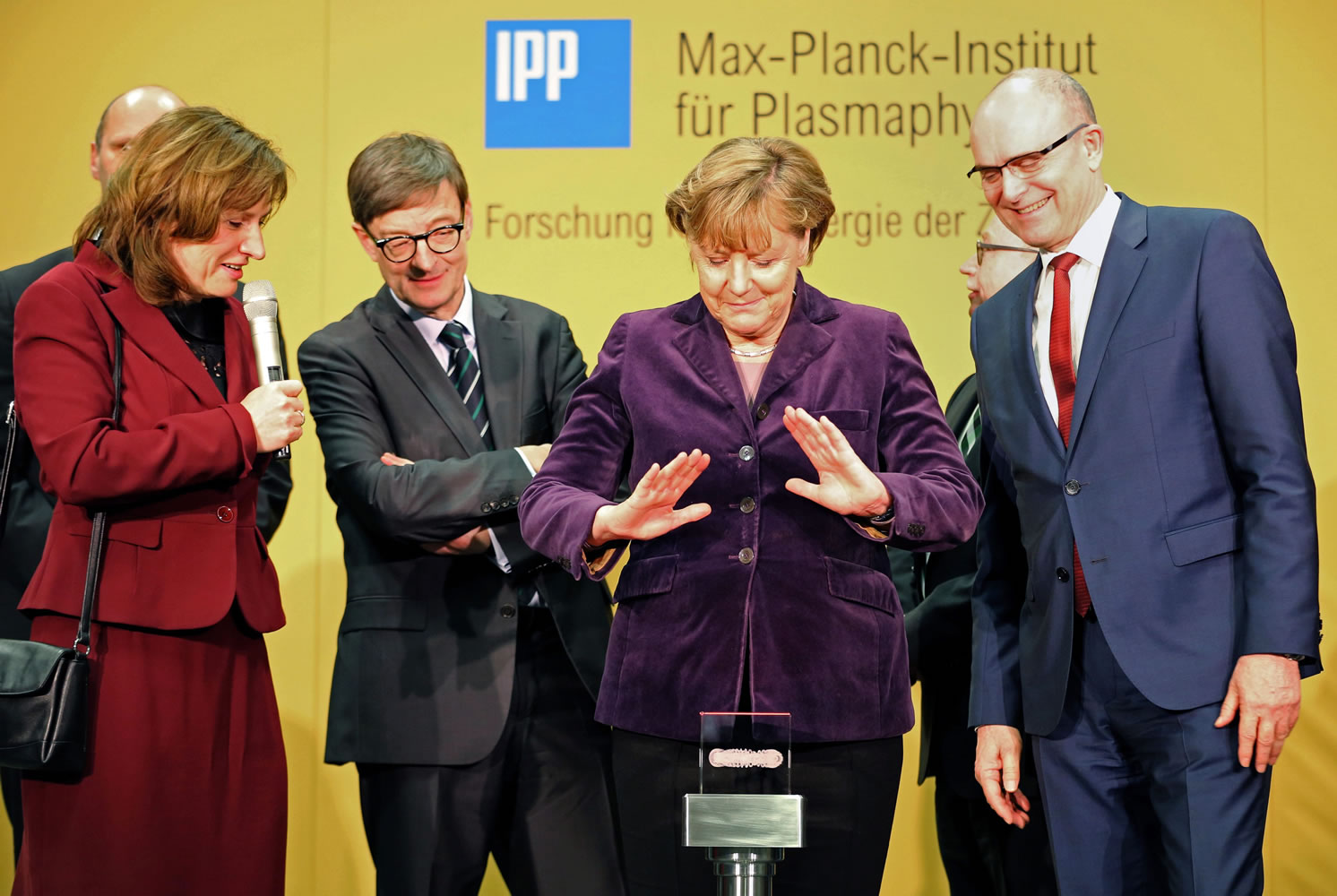 German chancellor Angela Merkel  prepares to press the start bottom next to the head of the Max Planck Institute for Plasma Physics  Sibylle Guenter, left, and Mecklenburg-Western Pomerania governor, Erwin Sellering, right, at the Wendelstein 7-X nuclear fusion research center at the Max-Planck-Institut for Plasma Physics in Greifswald, Germany, on Wednesday. Scientists flipped the switch  on an experiment they hope will advance the quest for nuclear fusion, considered a clean and safe form of nuclear power.