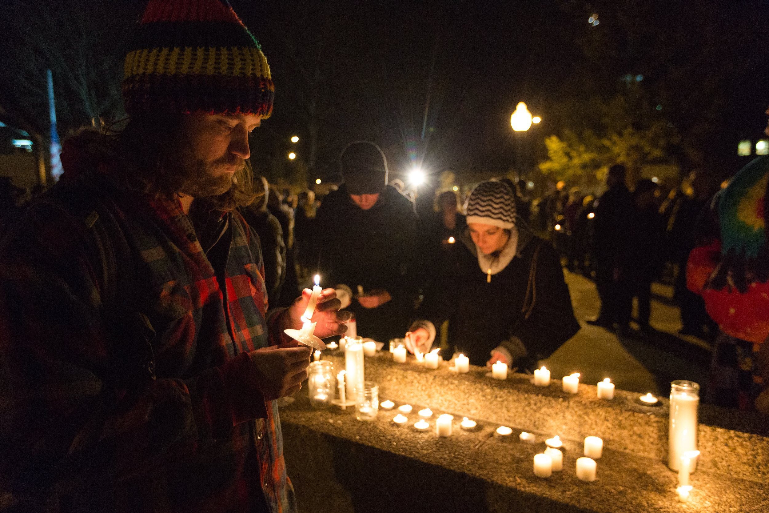 Joe Lucido lights a candle during the candlelight vigil at Bronson Park in remembrance of the mass shooting victims on Monday, Feb. 22, 2016, in Kalamazoo, Mich.