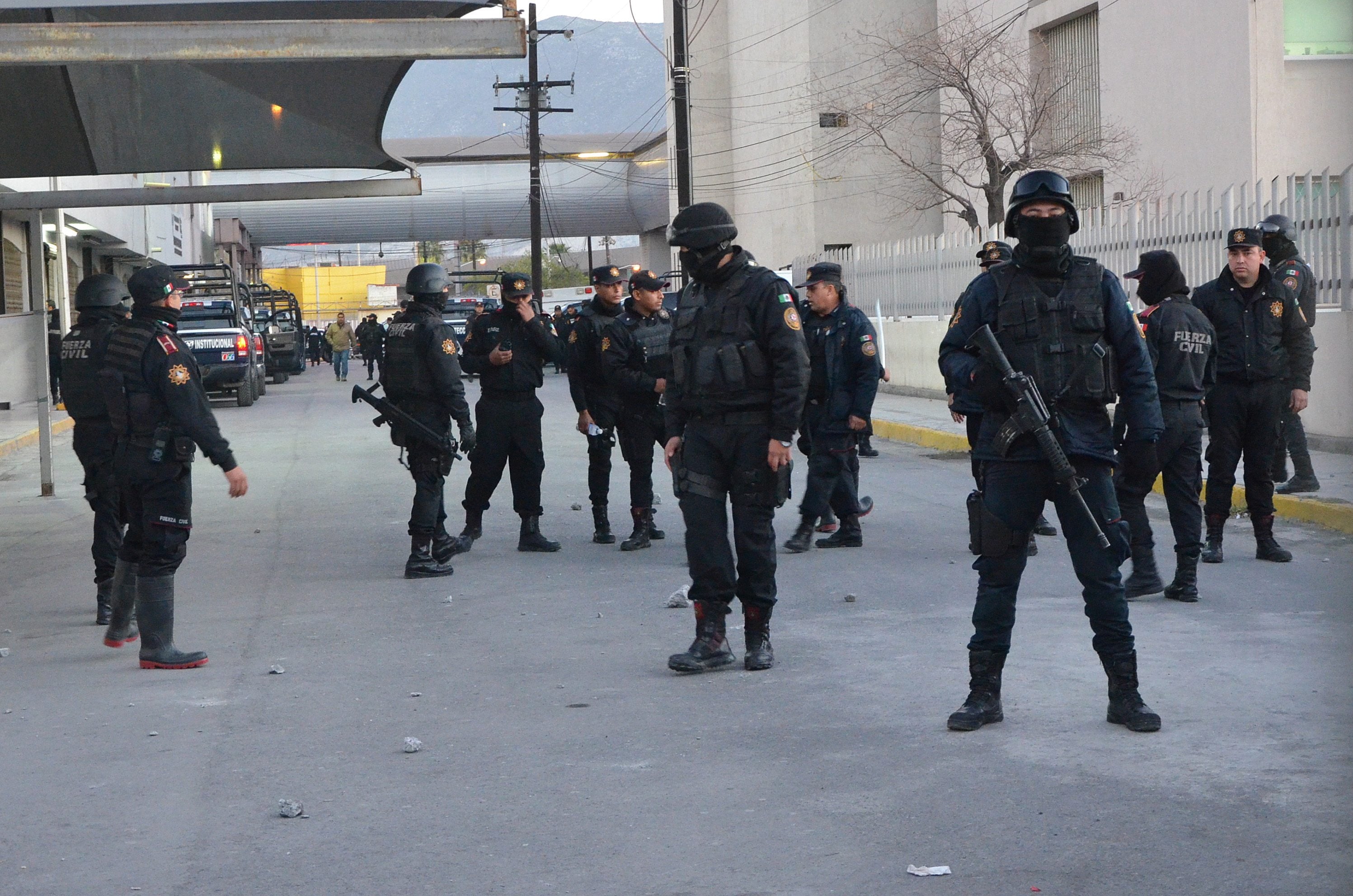 Police stand guard at the entrance of the Topo Chico prison, where a riot broke out just around midnight, in Monterrey, Mexico, on Thursday. Dozens of inmates were killed and several injured in a brutal fight between two rival factions at the prison in northern Mexico, the state governor said.