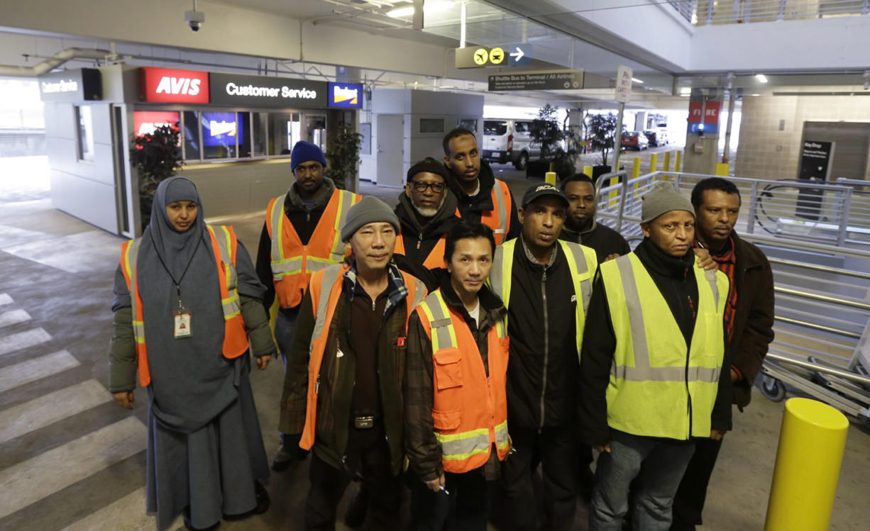 A group of people who work at the rental car facility at Seattle-Tacoma International Airport pose for a photo Wednesday while on break at their workplace. They are among Sea-Tac Airport workers who are suing their employers over the $15 minimum wage they say they have not been paid. (Ted S.