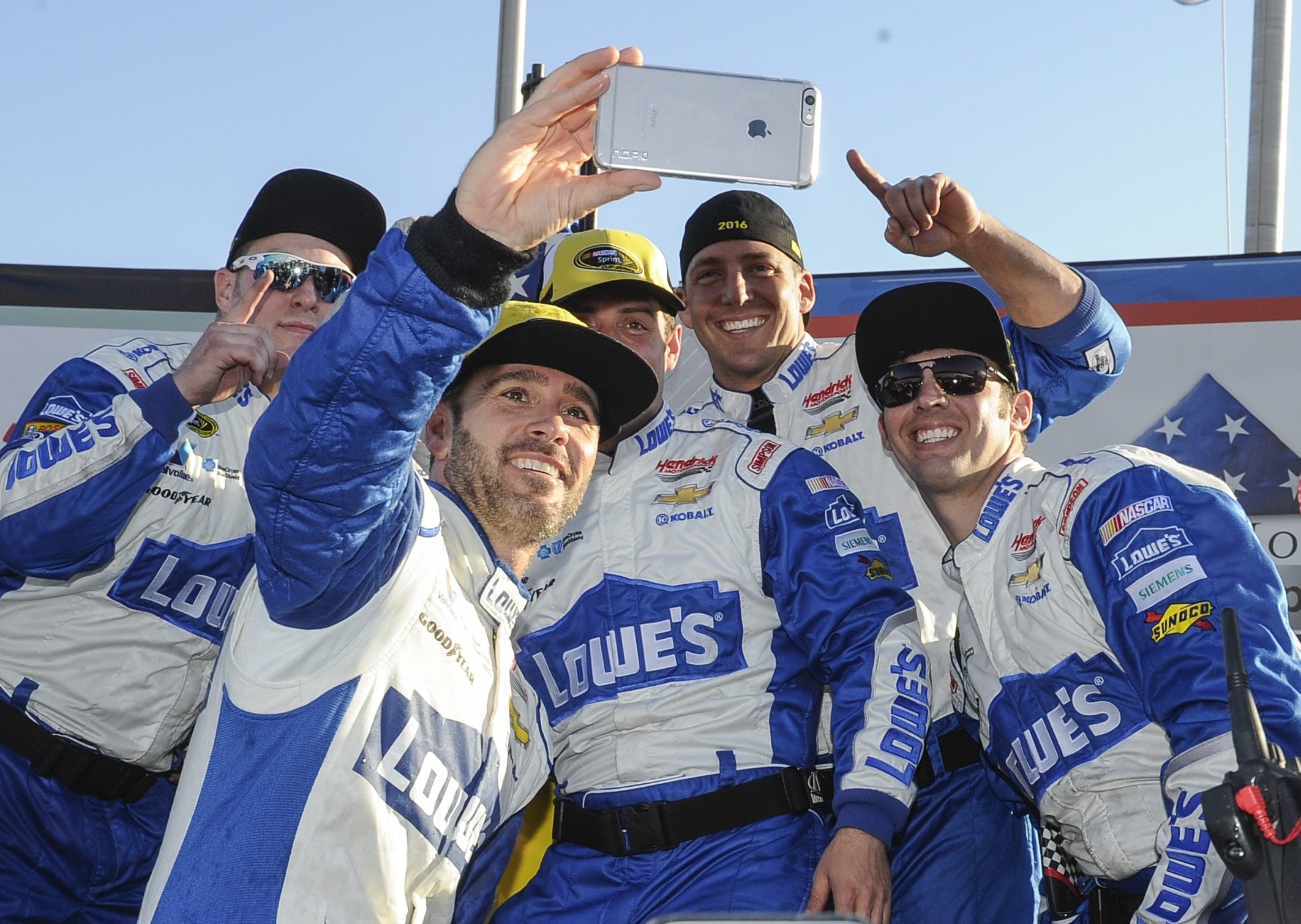Jimmie Johnson, second from left, takes a selfie with his crew after winning a NASCAR Sprint Cup Series auto race at Atlanta Motor Speedway on Sunday, Feb. 28, 2016, in Hampton, Ga.