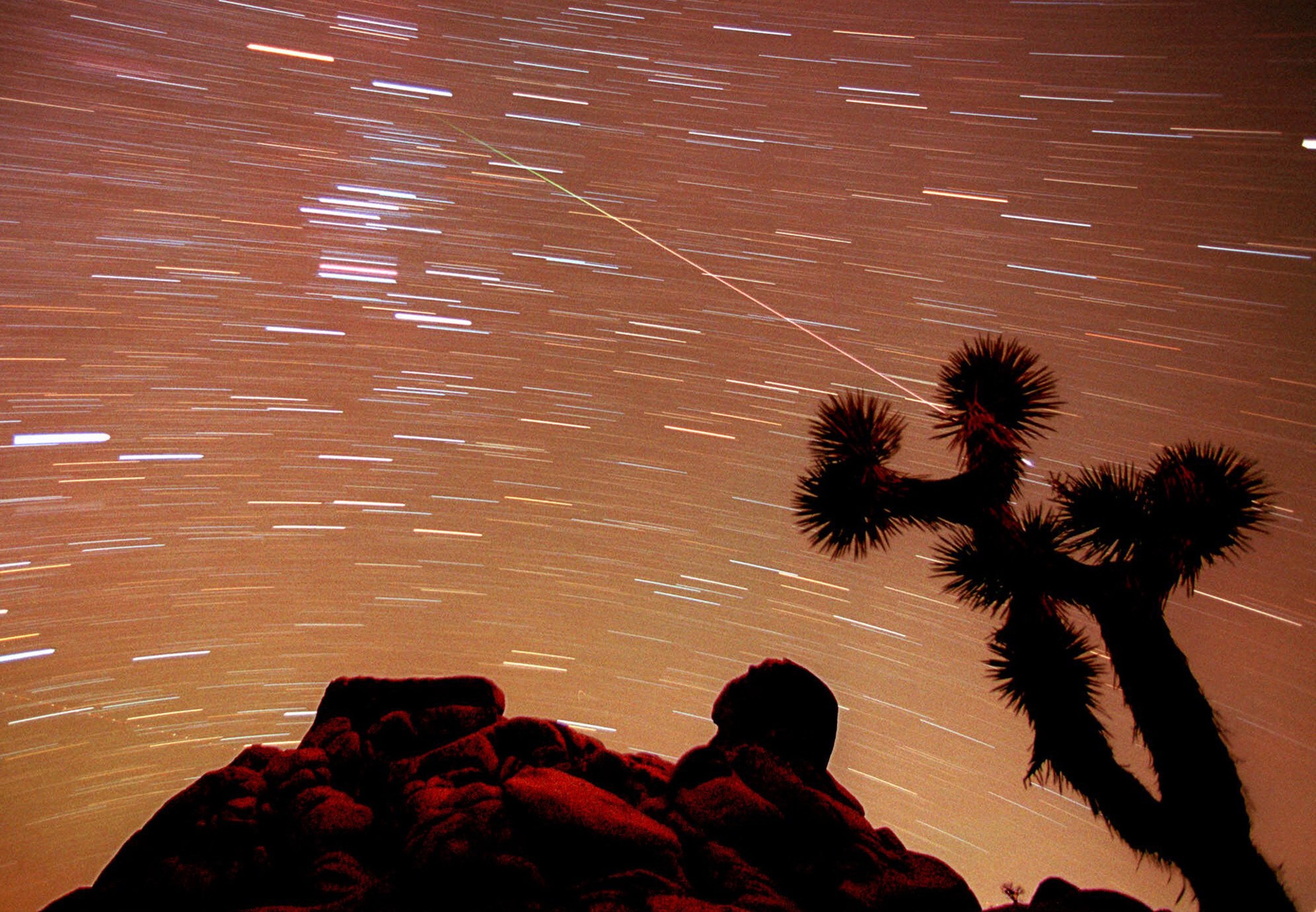 A meteor streaks through the sky over Joshua trees and rocks at Joshua Tree National Monument in Southern California&#039;s Mojave Desert. President Barack Obama is granting national monument status to nearly 1.8 million acres of scenic California desert wilderness, including land that would connect what is now Joshua Tree National Park to other established national monuments and national parks in the area. Obama, in California this week for a fund-raising swing, plan to make the announcement Friday, Feb. 12, 2016.