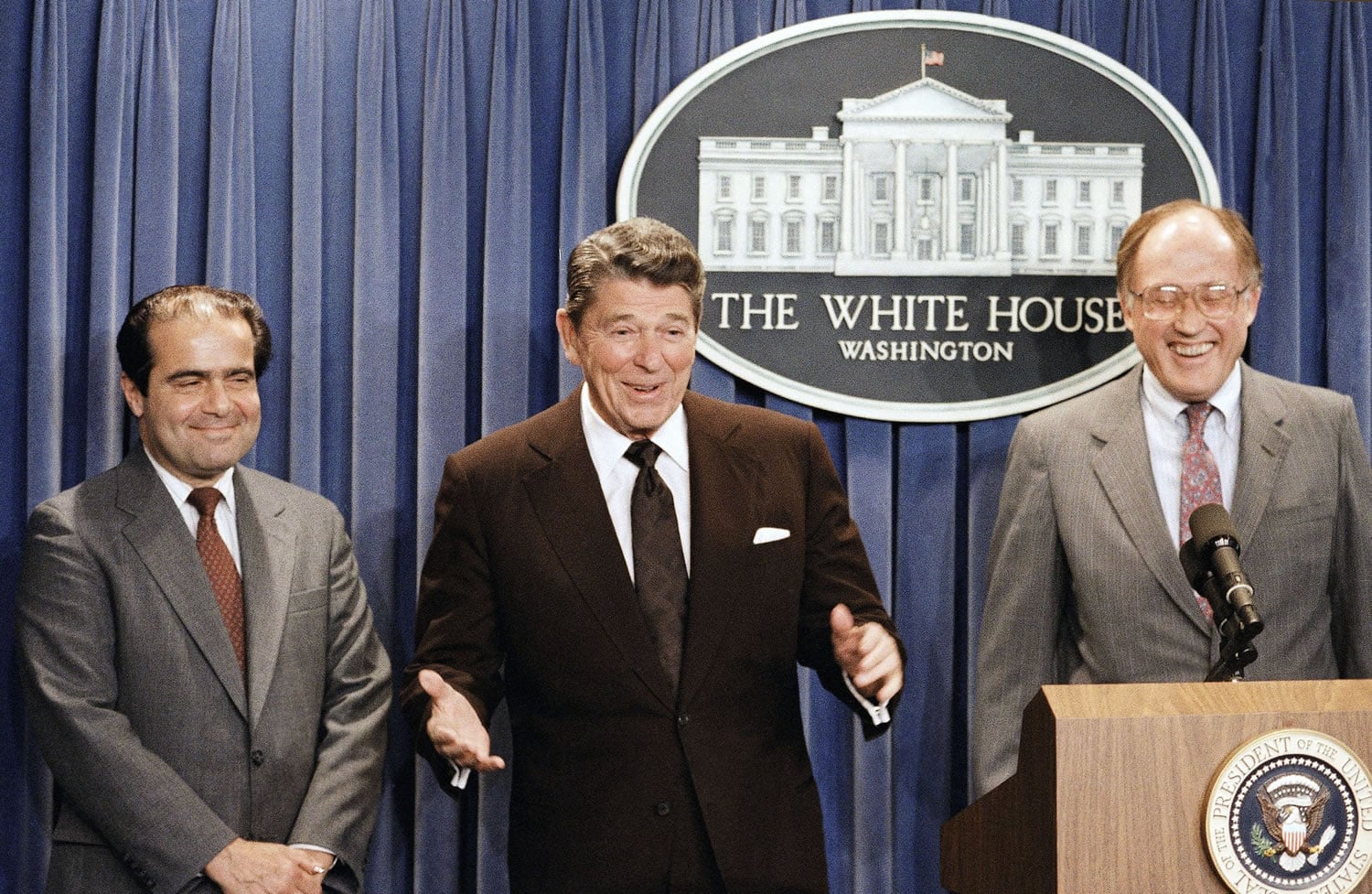 In this June 17, 1986 file photo, President Ronald Reagan speaks at a news briefing at the White House in Washington, where he announced the nomination of Antonin Scalia, left, to the Supreme Court as a result of Chief Justice Warren E. Burger's resignation. William Rehnquist is at right. On Saturday, Feb. 13, 2016, the U.S. Marshals Service confirmed that Justice Scalia has died at the age of 79.