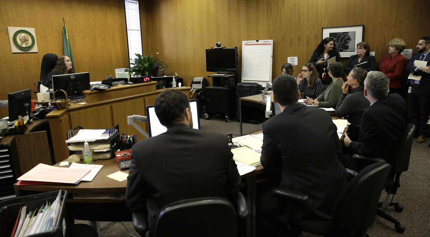 Judge Regina Cahan, left, presides over a packed juvenile courtroom in Seattle on Tuesday before the appearance of one of three teens who were arrested Monday and are suspected in a drug-related shooting that left two people dead and three wounded at a well-known Seattle homeless camp. (AP Photo/Ted S.