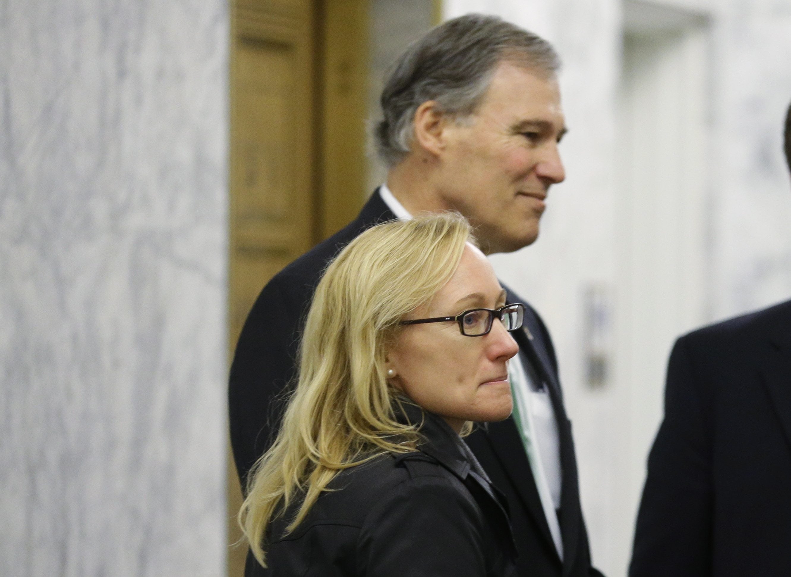 Ousted Washington state Secretary of Transportation Lynn Peterson, lower left, stands with Washington Gov. Jay Inslee before Inslee talked to reporters about the upcoming 2014 legislative session at the AP Legislative Preview in Olympia. (AP Photo/Ted S.