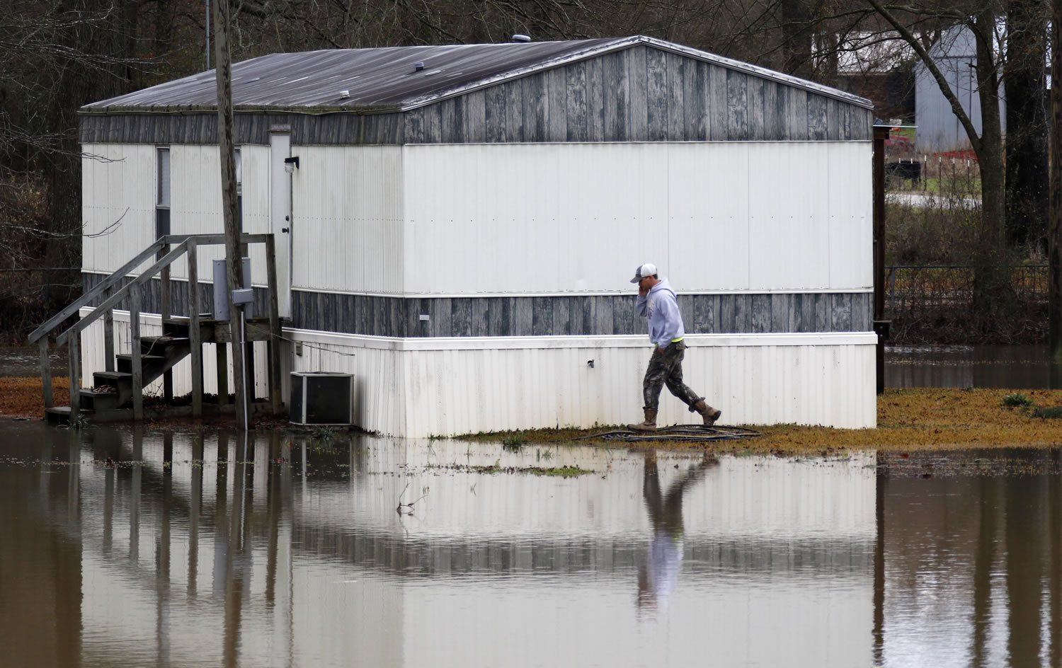 An area resident walks carefully around the Pelahatchie Creek floodwaters that surround a mobile home adjacent to U.S. Highway 80 East near Pelahatchie, Miss., on Wednesday as several communities in east Mississippi dealt with flash flooding from the severe weather that swept through Mississippi and other states on Tuesday. The National Weather Service is trying to determine how many tornadoes touched down in Mississippi. (AP Photo/Rogelio V.
